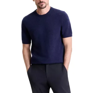 A man is wearing a short-sleeved navy knit sweater paired with dark pants.