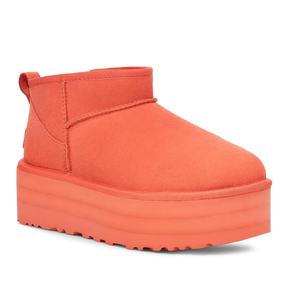 A single bright orange platform boot with a chunky sole and a short shaft.