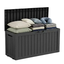 A black storage box filled with pillows and folded blankets, featuring a vertical panel design and a hinged lid.