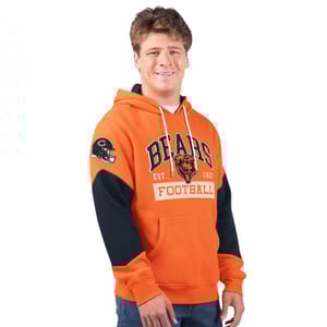 A man is wearing a bright orange hoodie with \“BEARS\“ and a bear graphic on the front, indicative of NFL team merchandise, but no additional T-shirts are visible in this photo.