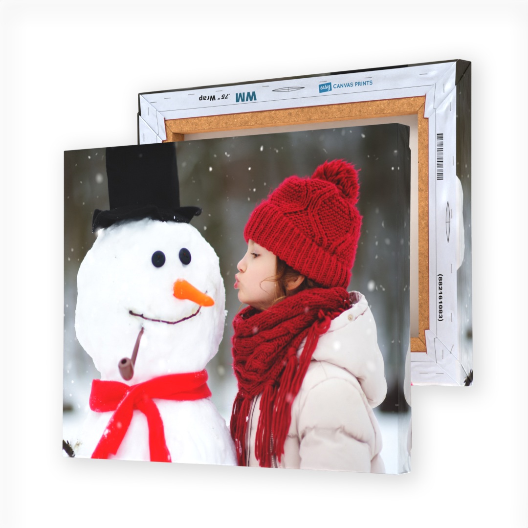 A canvas print features a child in a red hat and scarf interacting with a snowman wearing a black top hat and red scarf, set in a snowy backdrop.