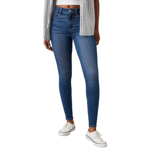 A person is wearing blue skinny jeans, paired with a gray striped shirt and white sneakers.