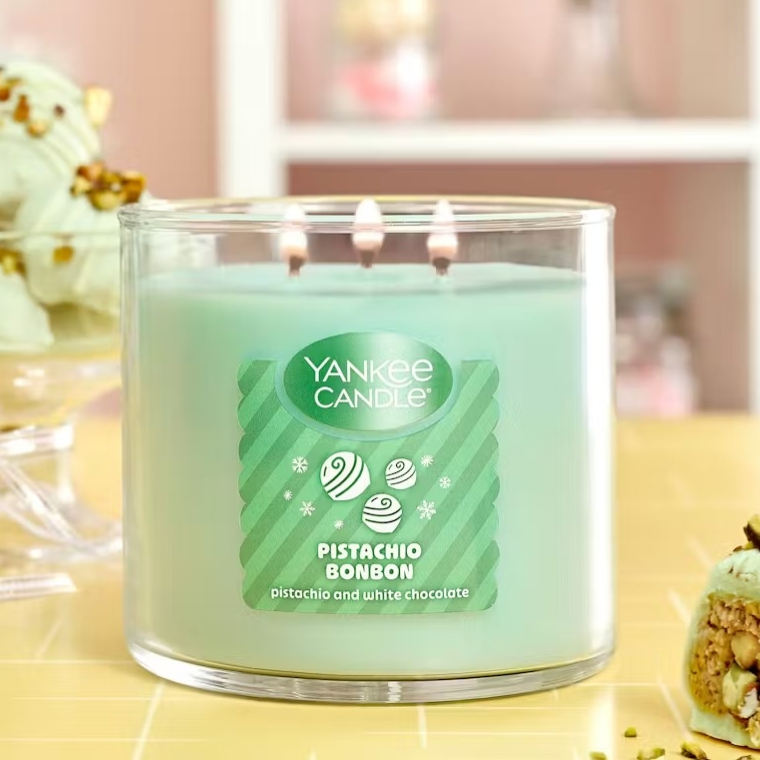 Yankee Candle Pistachio Bonbon with a pistachio and white chocolate scent is shown next to pistachio-themed desserts in a pastel setting.