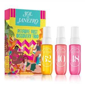 Three Sol de Janeiro perfume mist bottles in yellow, pink, and red are displayed in front of their vibrant, tropical-themed packaging.