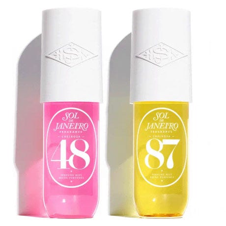 Two Sol de Janeiro body fragrance mists are shown: one with a pink bottle labeled \“48\“ and another with a yellow bottle labeled \“87,\“ each featuring a white cap.