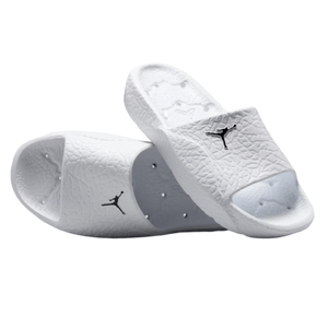 A pair of white slide sandals featuring a black logo, textured with a design reminiscent of elephant print.
