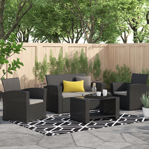 A 4-piece patio set featuring a sleek black rattan finish, including two armchairs, a loveseat with gray cushions, and a coffee table, all arranged on a geometric-patterned rug, with yellow and gray accent pillows enhancing the modern outdoor setting.