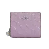 Pink Coach wallet with embossed signature pattern and silver logo, featuring a zipper pull with a decorative charm.