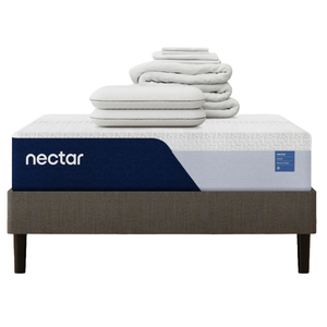 Nectar mattress with blue and white cover, featuring memory foam. Includes two stacked pillows and folded bedding, all placed on a dark gray bed frame with four legs.