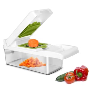 Vegetable chopper with a dicing blade, featuring a container for collecting chopped pieces, showing diced carrots. Nearby, whole vegetables include a cucumber, tomato, and red bell pepper.