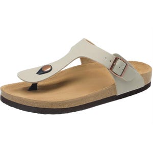 Beige sandal with a cork and rubber sole, featuring a thong strap with a metal button and an adjustable side buckle.