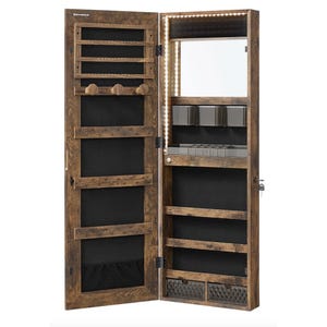 A wooden wall-mounted jewelry cabinet with an LED-lit mirror, multiple hooks, compartments, and shelves for organizing accessories.