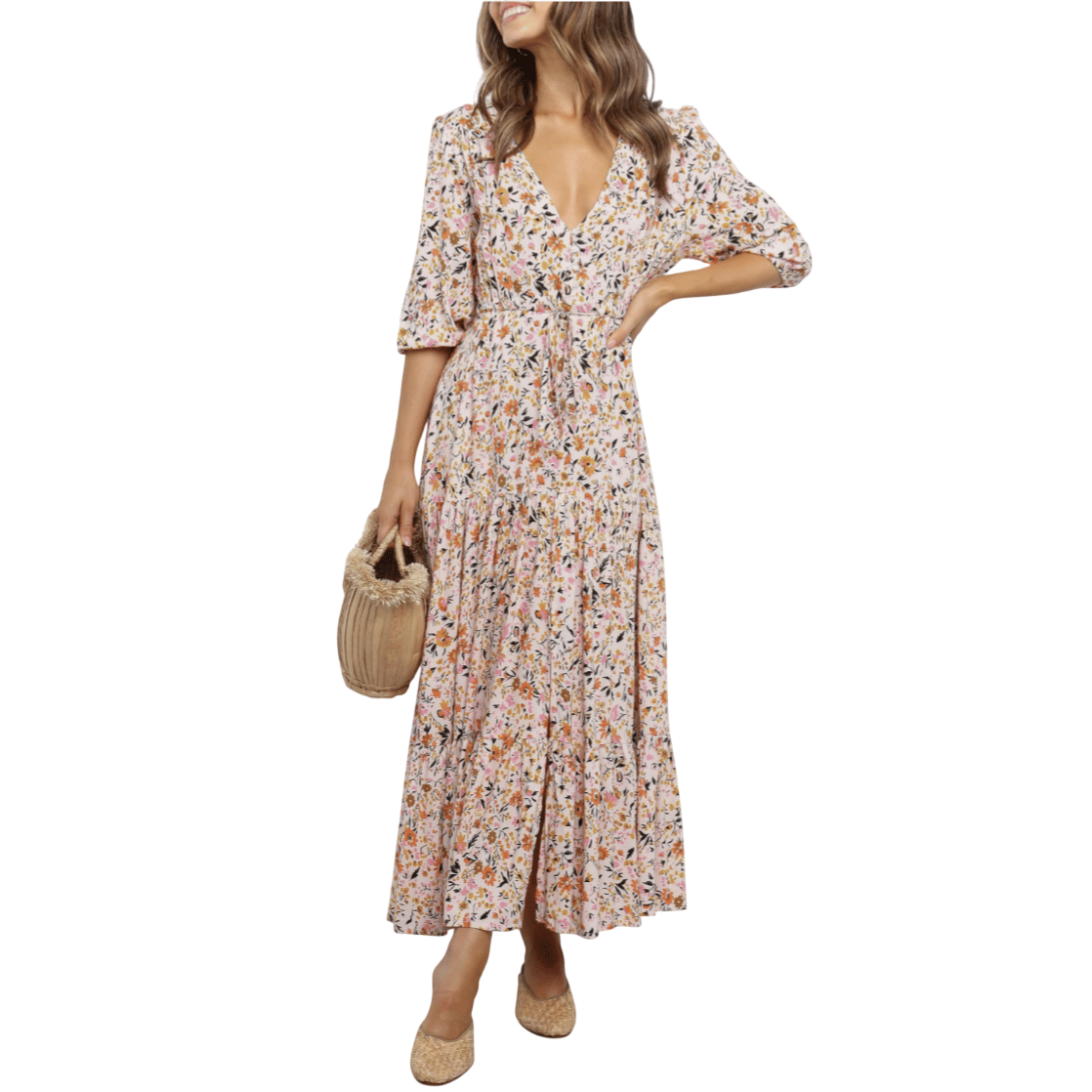 A woman wears a floral-patterned maxi dress with a V-neck and half sleeves, holding a woven basket bag and wearing flat woven shoes.