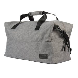 A large, gray duffel bag with black handles, designed for travel or everyday use, featuring a durable build and minimalistic look. It includes zip closures and an adjustable strap for versatile carrying options.