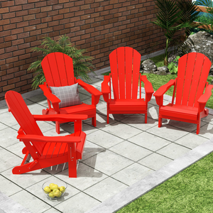 Four red Adirondack chairs are arranged on a patio with a brick wall backdrop. There is a gray cushion on one chair and a bowl of apples on the ground.