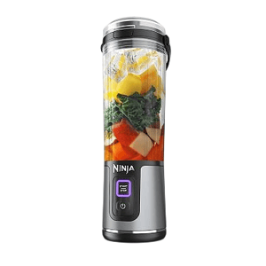 A Ninja brand portable blender with a clear blending cup filled with fruits and vegetables, featuring a power button and digital interface.