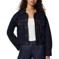 A person is wearing a dark denim jacket with button closures and contrasting stitching, paired with matching denim jeans and a white fitted tank top.