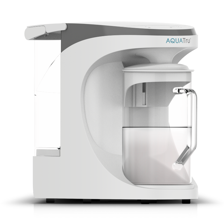 AquaTru Water Purifier Carafe is a sleek, countertop water filtration system with a clear bottom chamber and a white upper housing, featuring a brand logo on top.