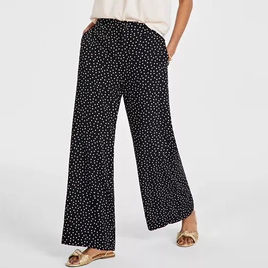 Black wide-leg pants with white polka dots and gold strap sandals.
