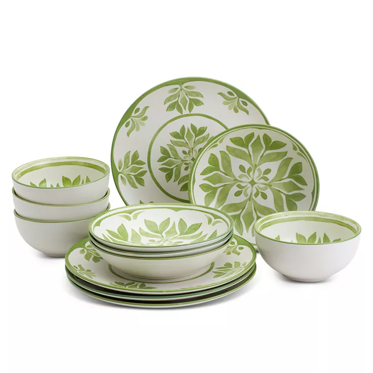 A dinnerware set featuring plates and bowls with a green leaf pattern on a white background.