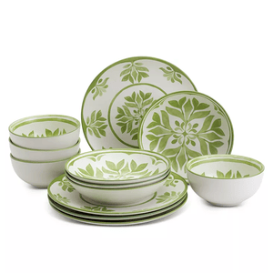 A dinnerware set featuring plates and bowls with a green leaf pattern on a white background.