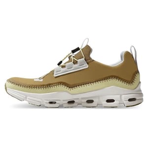 Tan and white sneaker featuring a mesh upper with unique lacing system, a distinctive wave-pattern stitch, and a cushioned, segmented sole for enhanced flexibility and comfort.