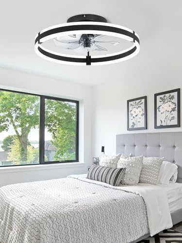 A modern bedroom featuring a ceiling fan light with a circular LED design above a bed with neutral-toned bedding and floral wall art.