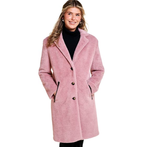 A woman is wearing a pink coat with a black turtleneck sweater.