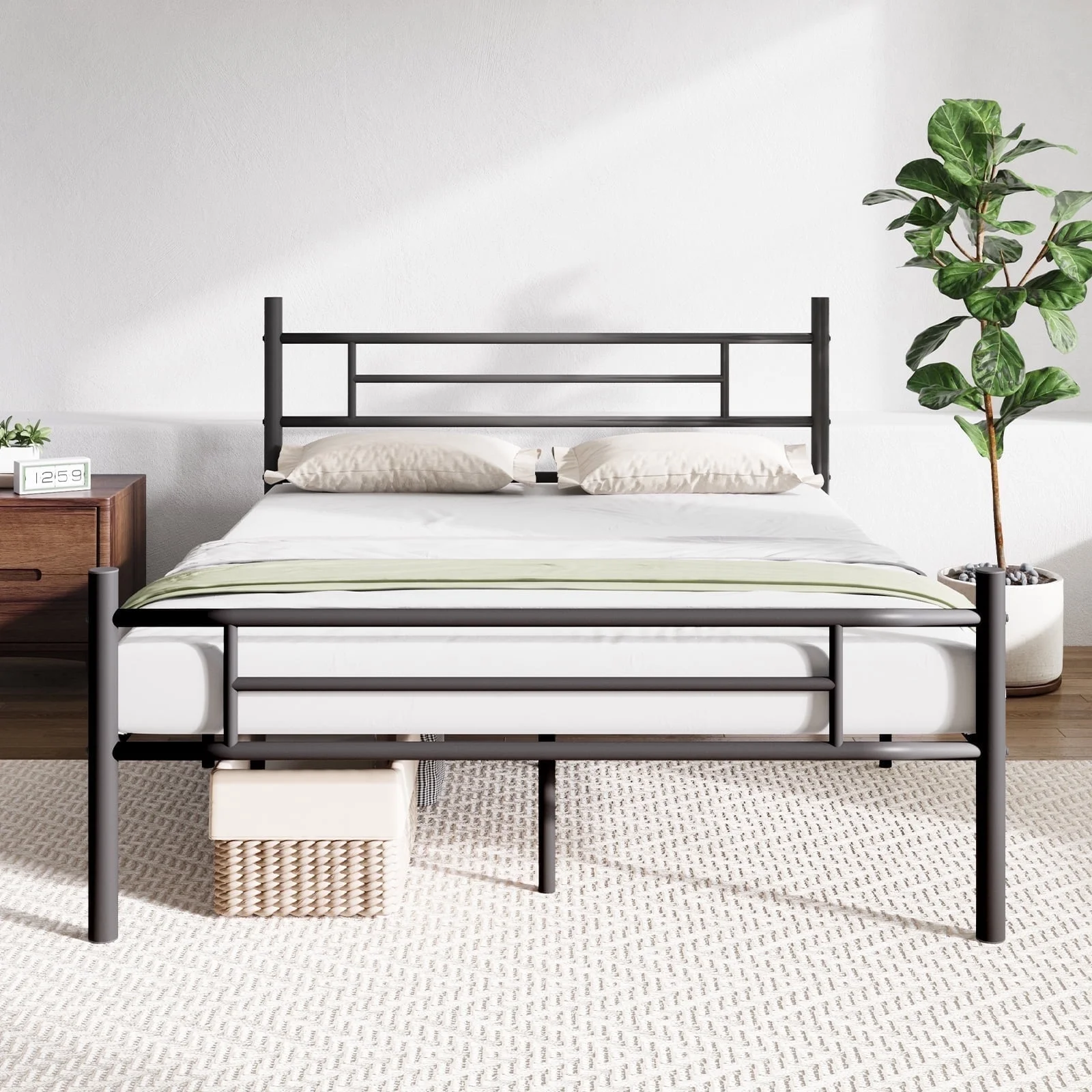 A metal bed frame with a headboard and footboard is shown, featuring pillows and a green-accented bedspread. It is set on a light textured rug, accompanied by a wooden nightstand with a digital clock and a potted plant nearby.