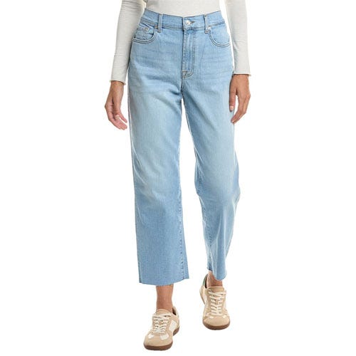 A person is wearing light blue straight-leg jeans paired with beige and white sneakers and a light-colored long-sleeve top.