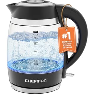 A clear glass and black plastic electric kettle with water level marks, a blue illumination feature, and a Chefman brand logo on it.