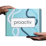 A Proactiv package is being held by two hands against a blue background. The box features a simple design with wavy lines and the brand's name prominently displayed.