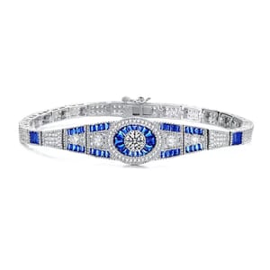 The Genevive Sterling Silver Blue CZ Bracelet features a central round clear cubic zirconia surrounded by blue baguette-cut stones and additional clear stones on a sterling silver band, creating an elegant, sparkling design.