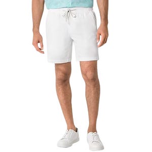 Men's white deck shorts with an elastic drawstring waistband, reaching above the knee, paired with white sneakers and a light blue shirt.