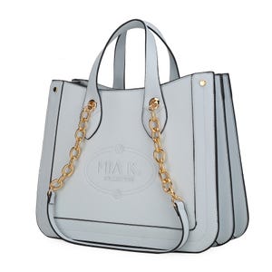 The MKF Faux-Leather Tote by Mia K. Collection is a stylish bag with gold-tone chain accents, dual handles, and a textured surface. It features the embossed logo on the front and has a structured, spacious design for practicality and elegance.