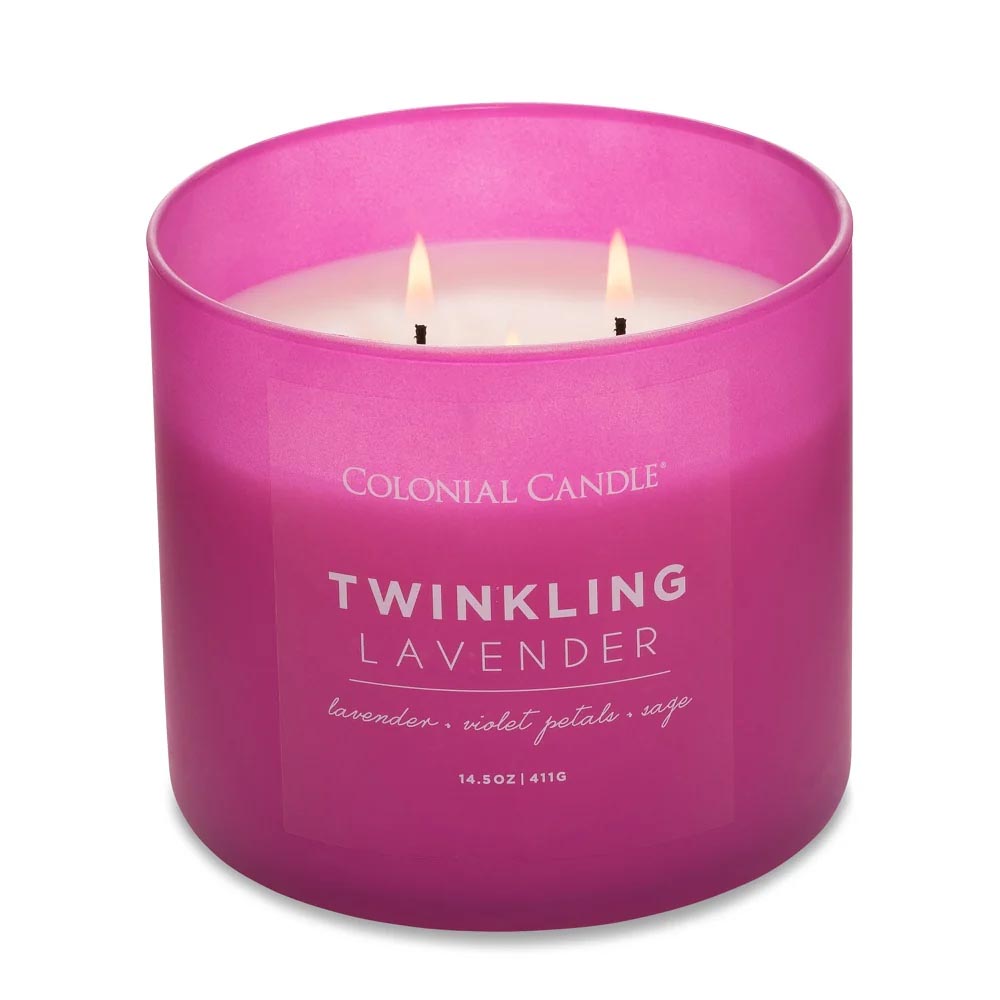 A pink Colonial Candle labeled \“Twinkling Lavender,\“ scented with lavender, violet petals, and sage. It has three wicks and weighs 14.5 oz (411g).