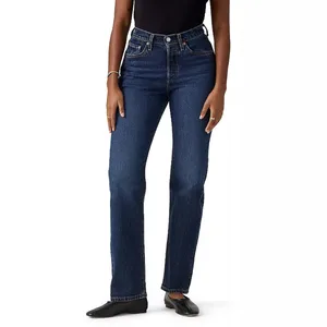 A person wearing high-waisted, dark blue straight-leg jeans with a black top and black shoes.