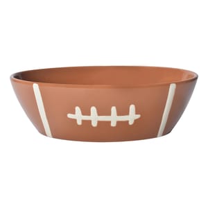 A ceramic serving bowl shaped like a football with white line and stitch details, 3-quart capacity. Ideal for game day snacks.