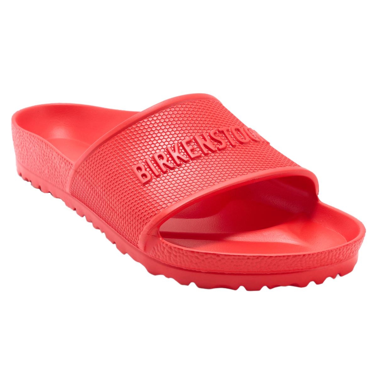Red Birkenstock slide sandal with a textured strap and logo embossed on the upper, featuring a contoured footbed and slip-resistant sole.