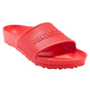 Red Birkenstock slide sandal with a textured strap and logo embossed on the upper, featuring a contoured footbed and slip-resistant sole.