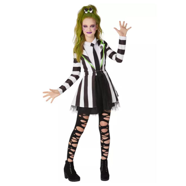A person is wearing a black and white striped costume with green hair accessories and ripped leggings.