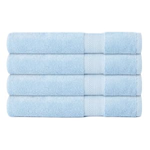 A stack of four light blue bath towels with a simple border design.