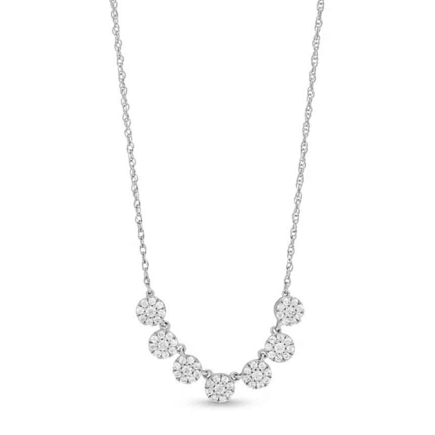 A white gold necklace featuring a series of seven circular clusters of diamonds, totaling 1/2 carat, arranged in a gentle, curved row.