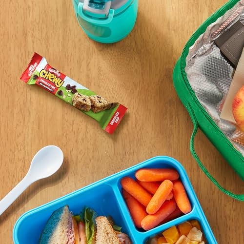 A lunch setup featuring a Quaker Chewy Chocolate Chip granola bar, a sandwich with carrots and fruit in a blue bento box, an aqua water bottle, and a green insulated lunch bag.