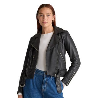 Black leather moto jacket with a classic design, featuring an asymmetrical front zipper, notched lapels, and zippered pockets. It is paired with a white shirt and blue jeans, offering a stylish and edgy look.