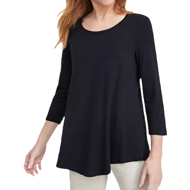 A woman is wearing a black, long-sleeve, A-line tunic top with a round neckline paired with light-colored pants.