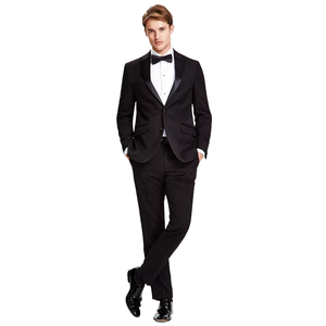 A man is wearing a sleek black Kenneth Cole Reaction tuxedo with a white dress shirt, black bow tie, and polished black shoes.