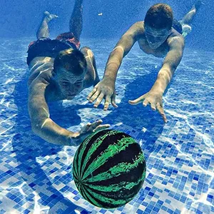 Two people are swimming underwater in a pool, reaching for a watermelon-patterned ball.