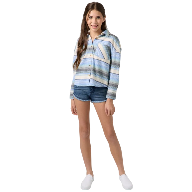 A young person is wearing a striped button-up shirt paired with denim shorts and white slip-on shoes.
