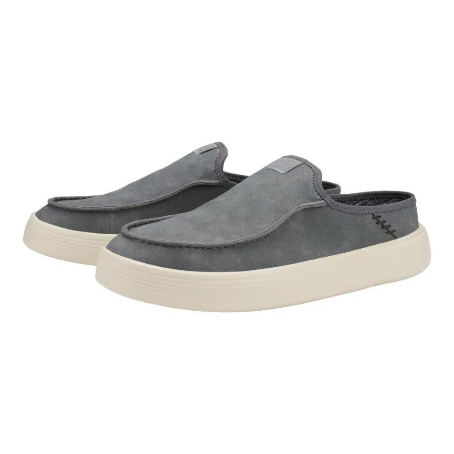 A pair of grey slip-on sneakers with thick white soles.